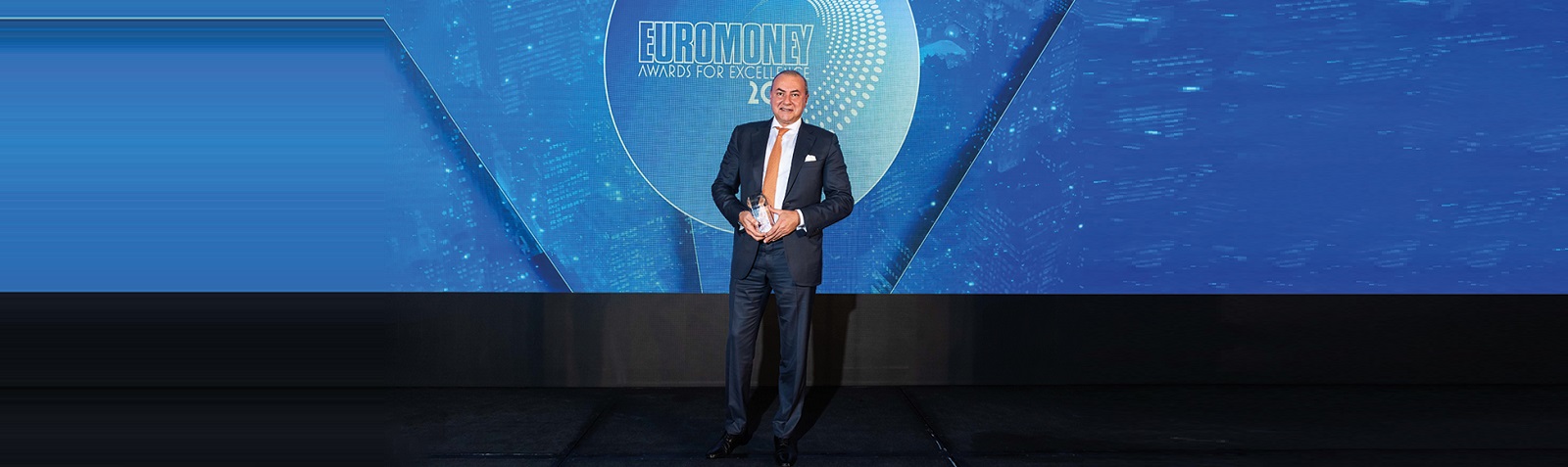 Image showing executive receiving industry excellence award on stage.