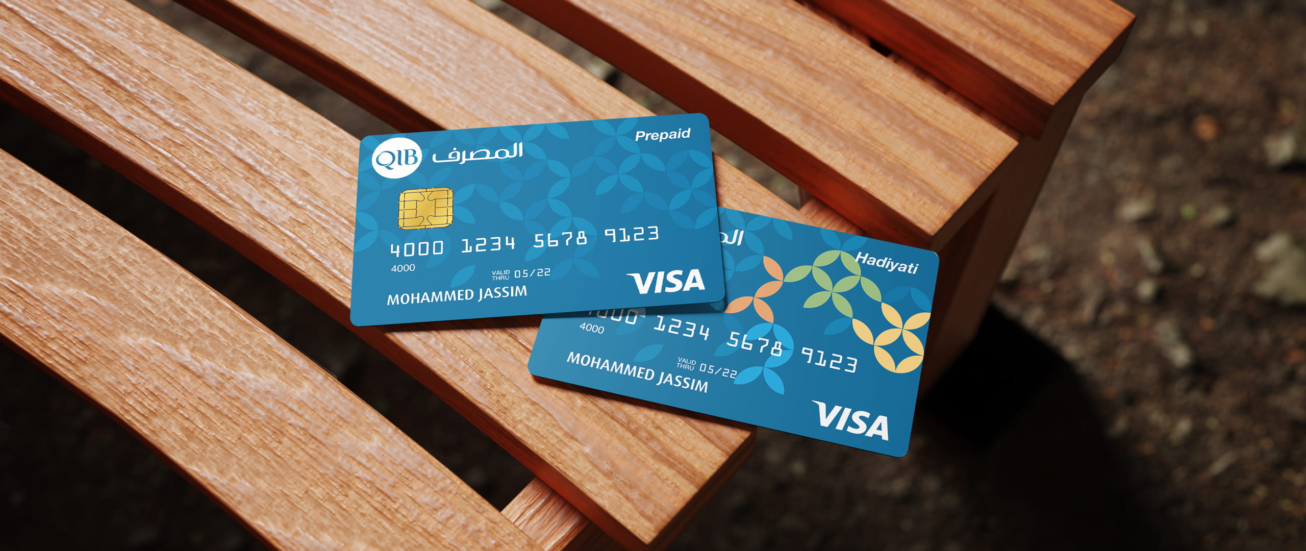 QIB reloadable and Hadiyati prepaid cards displayed on wood.